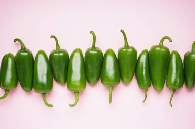 Pembe arka planda Jalapeno biberleri. Üst görünüm.
