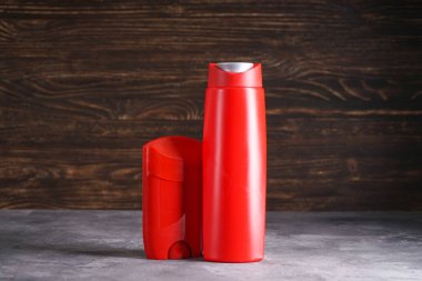 Ahşap arka planda bir şişe şampuan ve deodorant..