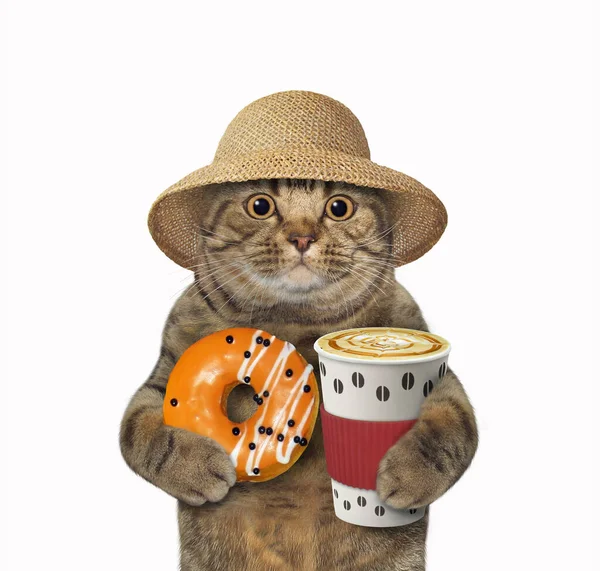Beżowy Kot Słomkowym Kapeluszu Trzyma Pomarańczowego Pączka Filiżankę Kawy Białe — Zdjęcie stockowe