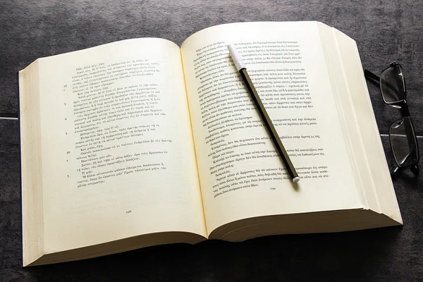 Büyük kitap, kalem ve gözlük 
