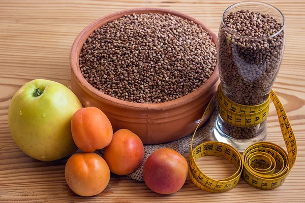 Concept - weight loss. Buckwheat in a ceramic pot, measuring tap — Stock Photo, Image