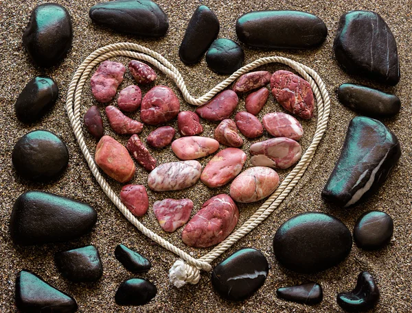 Η έννοια της αγάπης. Κοκκινωπό θάλασσα πέτρες, διατεταγμένα σε μια καρδιά sha — Φωτογραφία Αρχείου