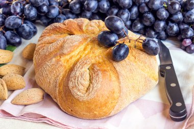 Taze renkli meyvelerin natürmort. Hafif bir arka plan üzerinde siyah üzüm, yeşil incir demet. Ekmek paket kağıt. 