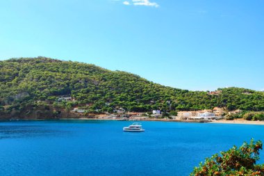 Açık deniz suyunda demirli küçük bir yatla harika bir körfez manzarası..