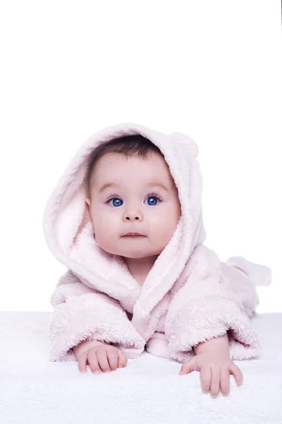 Cute baby child in pink bathrobe lying down on blanket — Stock Photo, Image