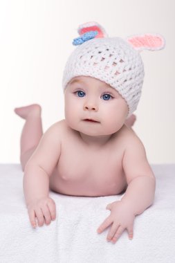 kulakları tavşanlı beyaz örgü şapkalı yatarken bebek