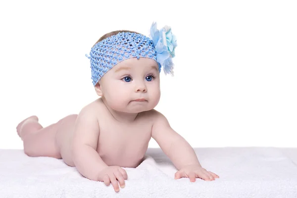 Маленька серйозна дитина з синьою квіткою на голові — стокове фото