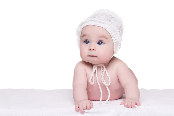 Baby child lying down on blanket wearing white hat, isolated — Stock Photo, Image