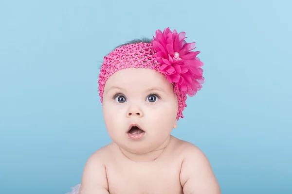 Bebê bonito com flor de arco rosa na cabeça — Fotografia de Stock