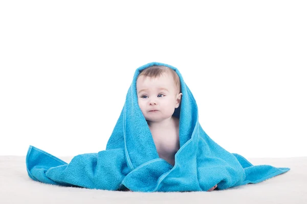 Cute baby sitting on blanket under blue towel/blanket — Stock Photo, Image