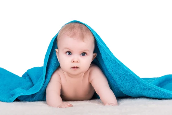 Baby child with big eyes under blue towel — Stock Photo, Image
