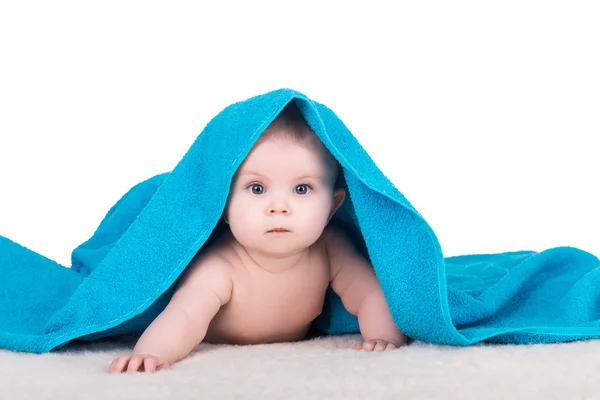 Baby child with big eyes under blue towel — Stock Photo, Image