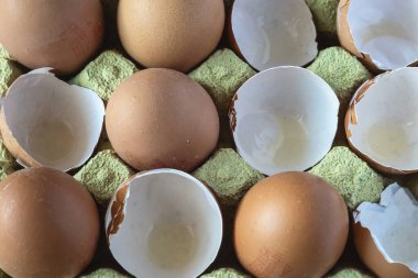 Tahta bir tahtanın üzerinde kırık yumurtalarla dolu bir kutunun yakın çekimi. Ev yemeği ve geleneksel tarifler için taze malzeme. Doğal ve kırsal stil.