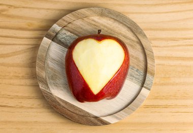 Elmaya oyulmuş, belirgin bir dokusu ve taze bir görüntüsü olan kalbin aşırı yakın çekimi.