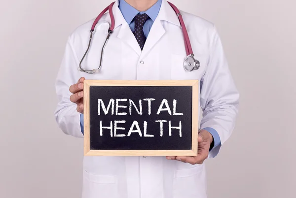 Doctor holding mini blackboard — Stock Photo, Image