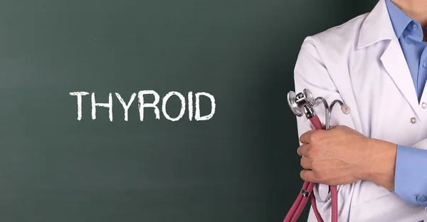 Doctor standing in front of blackboard — Stock Photo, Image