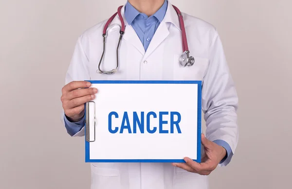 Doctor standing and holding clipboard — Stock Photo, Image