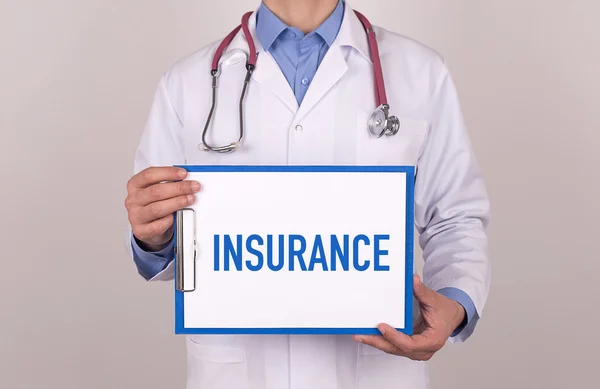 Doctor standing and holding clipboard — Stock Photo, Image