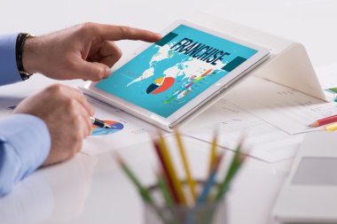 Tablet üzerinde çalışan iş adamı
