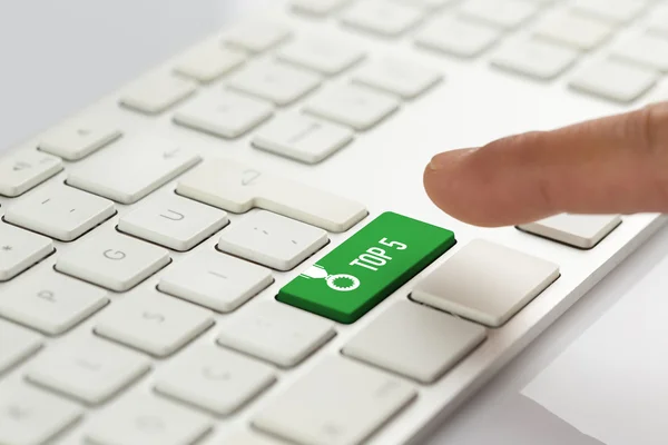 Палець натискає зелену кнопку клавіатури — стокове фото