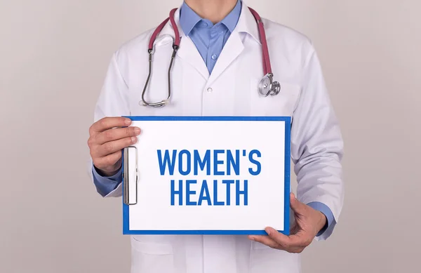 Doctor standing and holding clipboard — Stock Photo, Image