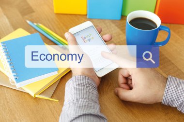 Cep telefonu ile masa üzerinde oturan adam