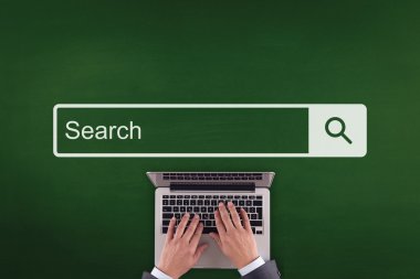 Laptop klavyesinde yazan kişi