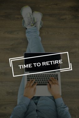 Genç adam dizüstü bilgisayarla yerde oturuyor.