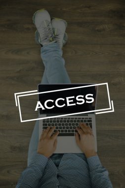 Genç adam dizüstü bilgisayarla yerde oturuyor.