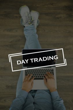 Genç adam dizüstü bilgisayarla yerde oturuyor.