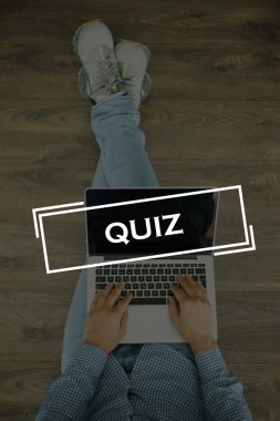 Genç adam dizüstü bilgisayarla yerde oturuyor.