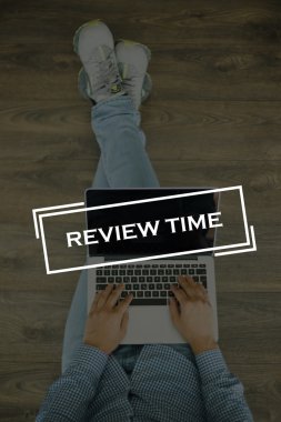 Genç adam dizüstü bilgisayarla yerde oturuyor.