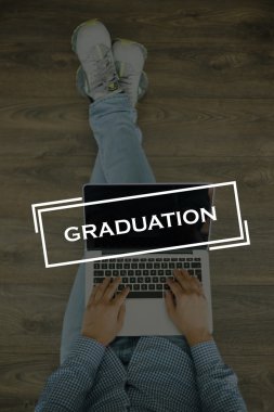 Genç adam dizüstü bilgisayarla yerde oturuyor.