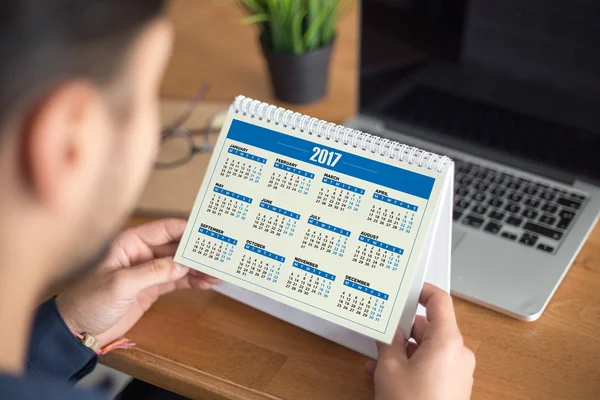 Comprobación de citas de hombre de negocios en el calendario 2017 — Foto de Stock