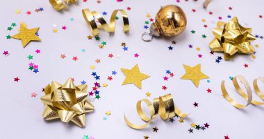 Konfeti in Shape Stars Gold Ribbons Red Christmas Balls on Blue Festive Holiday Card or Background Top View