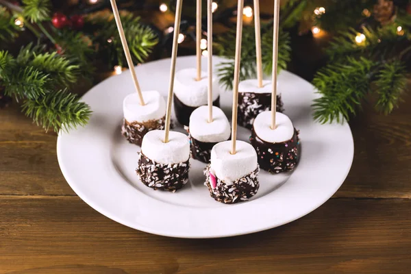 Christmas Dessert or Snack Marshmallow with Chocolate on White Plate Holiday Food Christmas Lights Fir Horizontal