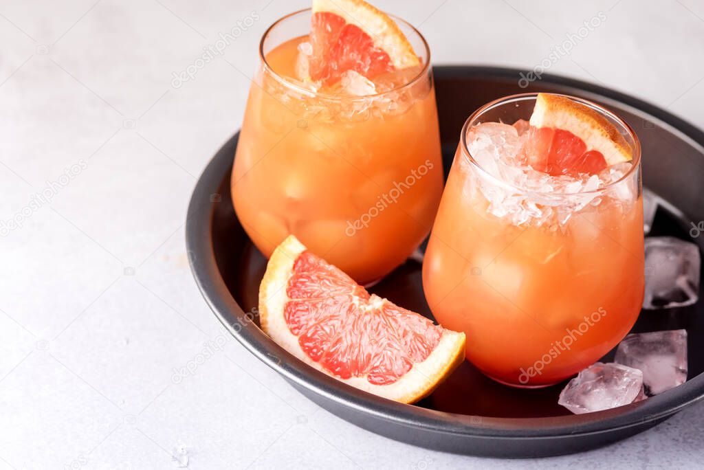 Glasses of Cold and Tasty Pink Grapefruit Juice Decorated with Slice of Ripe Grapefruit Cold Juice or Beverage Horizontal Copy Space