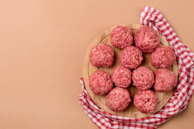Tahta tepside çiğ köfteler açık kahverengi arka planda yarı bitmiş yiyecek kopyalama alanı
