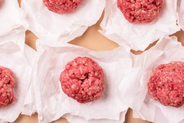 Beyaz Kağıt üzerinde ev yapımı taze pişmemiş biftek köfteleri. Yarı bitmiş et ürünü üst görünümü.