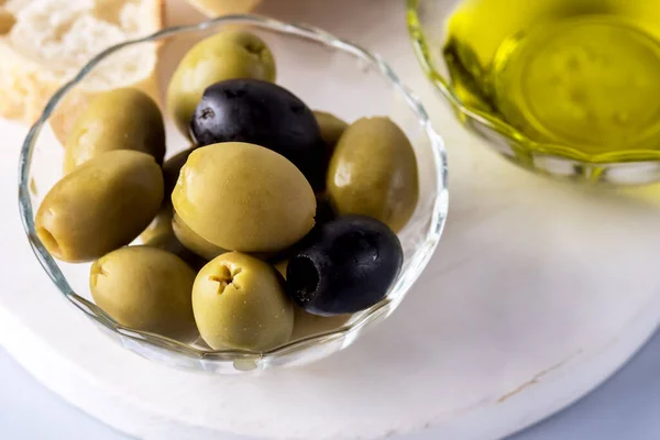 Bowls with Green and Black Olive Olive Oil on White Tray Artisan Bread Mediterranean Food Blue Background Above Horizontal