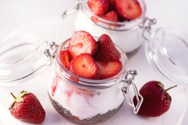 Sağlıklı Çilek Kahvaltısı Hindistan cevizi sütü ve Chia tohumları kavanozlarda Gri Yatay Arkaplanda