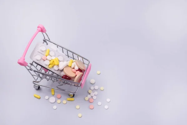 Carrito Compras Lleno Pastillas Concepto Fondo Azul Conjunto Medicamentos Tienda — Foto de Stock