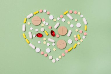 Yeşil Arkaplanda Renkli Haplardan Yapılan Kalp Şekli Özel Teklif İçin Tıbbi ve Sağlık Hizmeti Konseptini Kopyala Space Top View