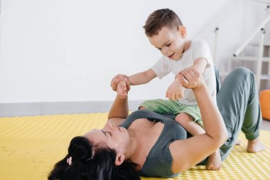 Özel merkezde serebral felçli çocuk rehabilitasyonu. Anne fiziksel egzersizler yapıyor ve engelli çocuklar için spor aktiviteleri yapıyor. Katılım ve hareketlilik Gerçek insan hayatı