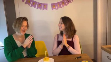 Arkadaşlar doğum gününü kutluyor. Yetişkin kadınlar süslenmiş evlerinde mum yanan doğum günü pastalarını, sıcak dostluk kutlamalarını ve şenlikli çelenkleri severler.