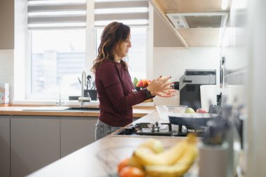 Modern mutfakta turta veya hamur işi için hamur yoğuran kadın taze meyve, geleneksel pişirme ve ev yemeği etkinliği ile