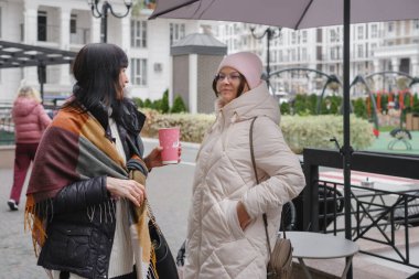 Mutlu çok nesilli bayan arkadaşlar soğuk bir günde dışarıda buluşmaktan, akıllı telefonları kontrol etmekten ve hatıraları neşeli bir selfie ile çekmekten hoşlanırlar.