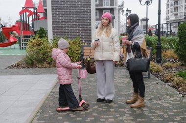Mutlu çok nesilli bayan arkadaşlar soğuk bir günde dışarıda buluşmaktan, akıllı telefonları kontrol etmekten ve hatıraları neşeli bir selfie ile çekmekten hoşlanırlar.