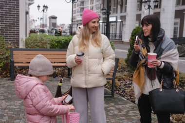 Mutlu çok nesilli bayan arkadaşlar soğuk bir günde dışarıda buluşmaktan, akıllı telefonları kontrol etmekten ve hatıraları neşeli bir selfie ile çekmekten hoşlanırlar.