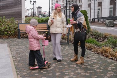 Mutlu çok nesilli bayan arkadaşlar soğuk bir günde dışarıda buluşmaktan, akıllı telefonları kontrol etmekten ve hatıraları neşeli bir selfie ile çekmekten hoşlanırlar.